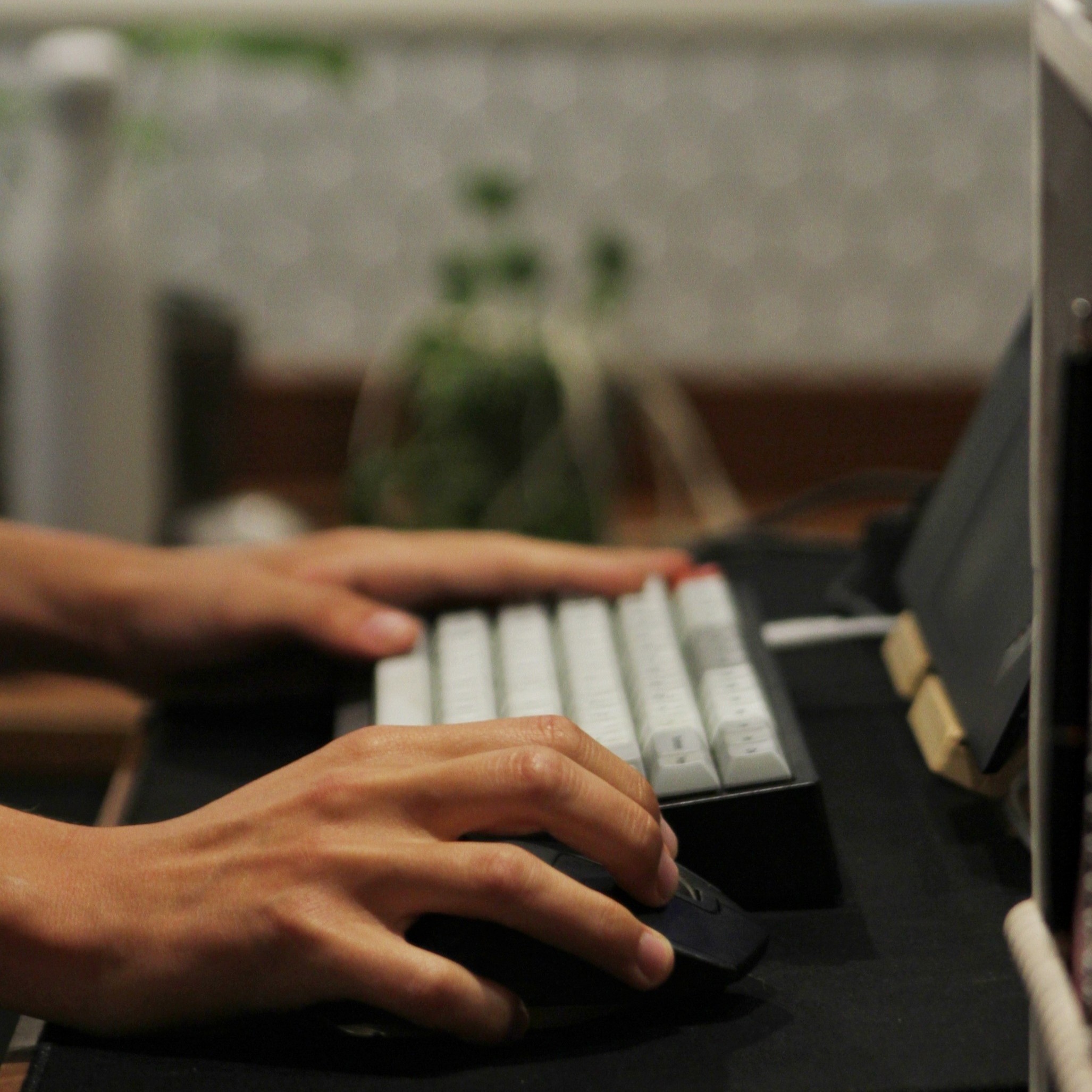 Keyboard and hands on desk with blurry background